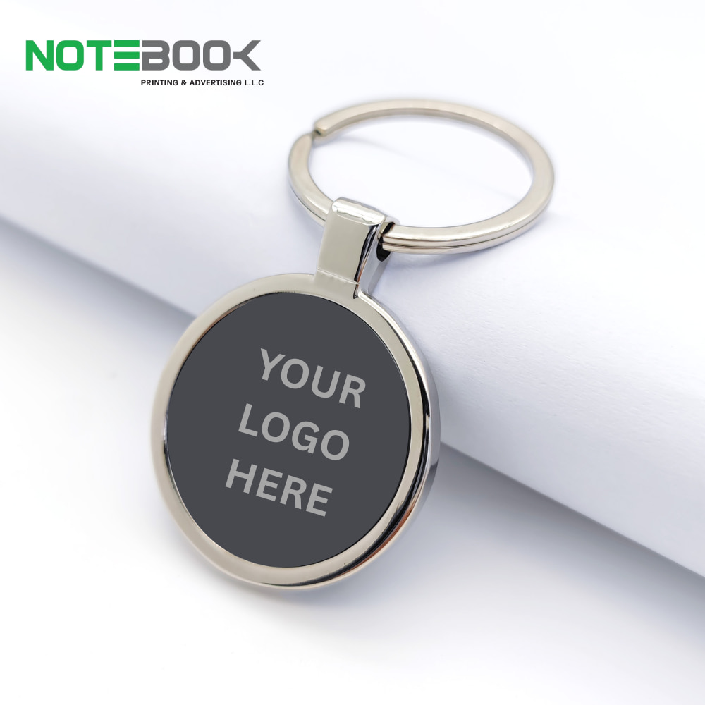 Personalized black round metal keychain with custom logo laser engraved in Dubai